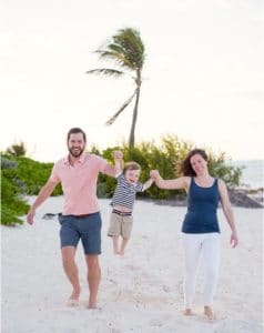 Two parents and a child on the beach.