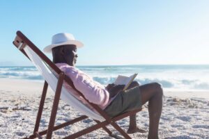 A man on the beach reading Far Tortuga.